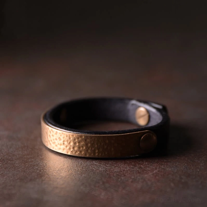 Tibetan copper black leather wealth bracelet with brass rivets and adjustable sizing, modern spirituality accessory