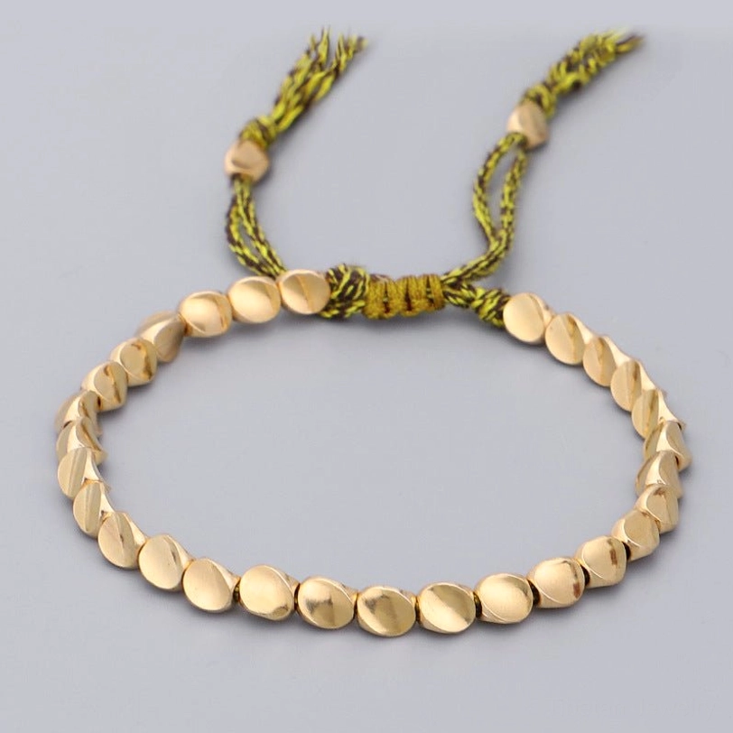 Green-yellow woven Tibetan copper bracelet with matte gold beads and mixed rope tassel