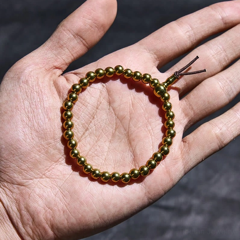 Small handcrafted copper beaded bracelet held in palm showing size and craftsmanship