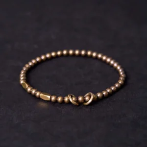 Tibetan copper brass couple bracelet flat lay with toggle clasp design, showing polished round beads on dark background