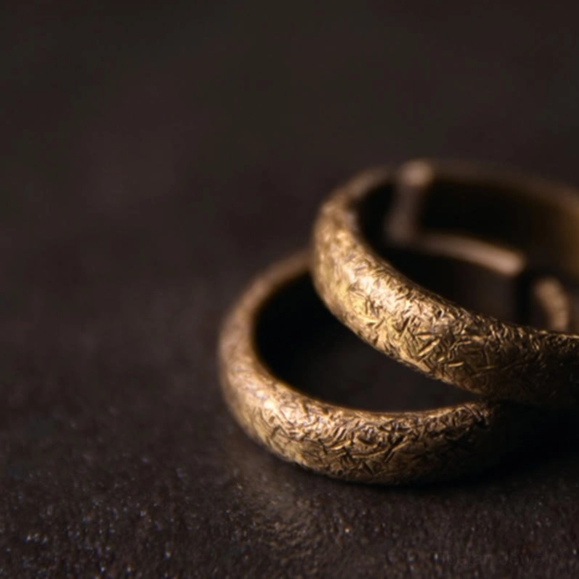 Two Tibetan vintage textured copper rings elevated display - low angle overhead showing nested matching antique bronze rings with rough surface