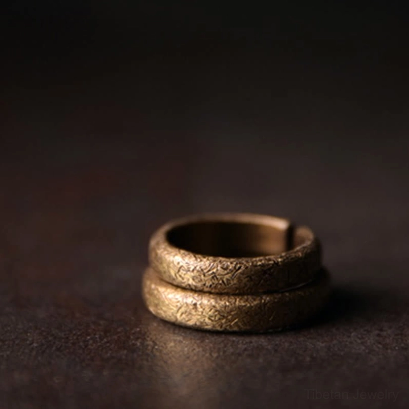 Two nested Tibetan vintage copper rings stacked - top down side view showing matching textured bands with rough bronze patina