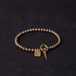 Tibetan copper prosperity bracelet with good luck charm flat lay top view featuring antique bronze beads and engraved square pendant