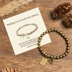 Tibetan copper luck bracelet with engraved good luck charm tag, flat lay on wooden surface with natural decor