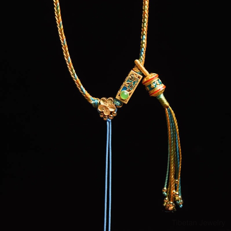 Close-up of Tibetan braided copper necklace with gold-teal rope green enamel charm and flower accent