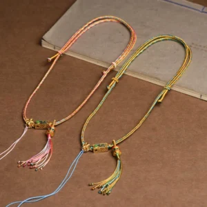 Two Tibetan braided copper necklaces side by side in pink and yellow-blue color variations showing product diversity