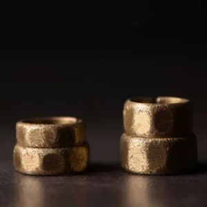 Tibetan frosted copper prosperity rings - stacked pairs showing 6mm and 10mm band widths in warm bronze finish on dark background