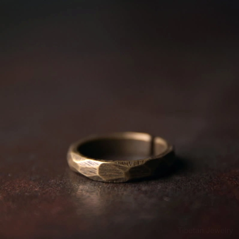 Single open cuff copper ring front view brushed hammered texture dark background