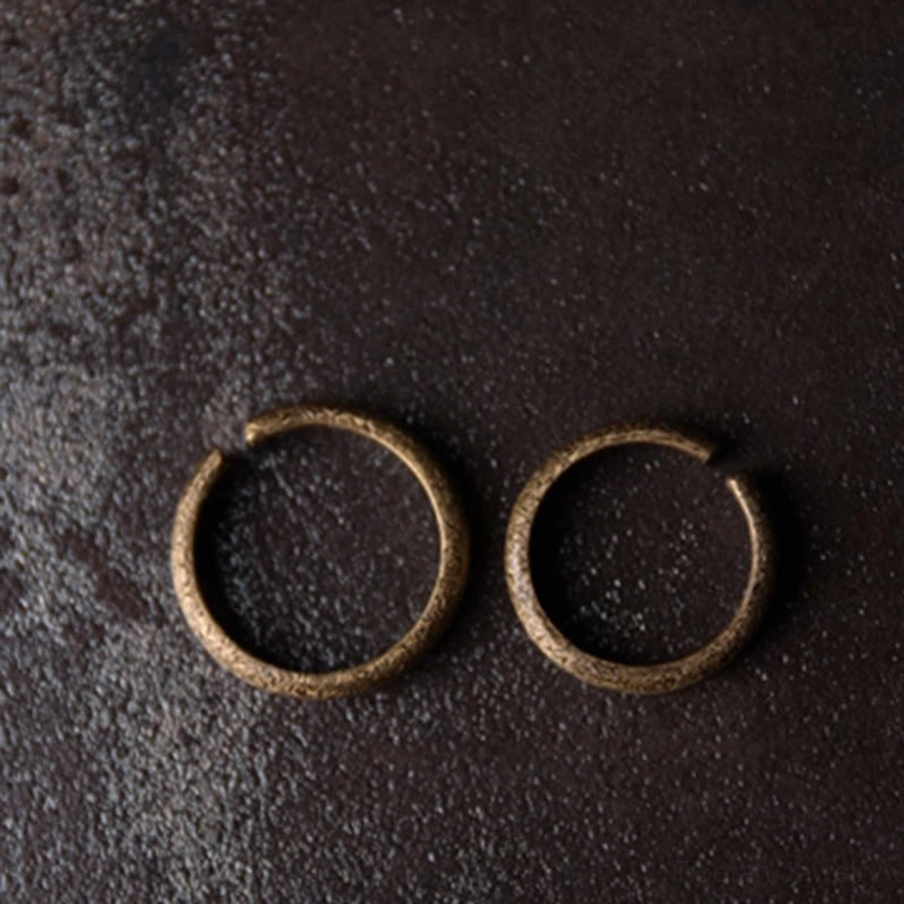 Pair of slim 2mm Tibetan vintage copper rings - flat overhead minimalist design on leather surface showing thin delicate band