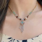 Tibetan crystal stone copper tassel necklace worn on model, showing authentic handmade beaded chain with jade accents and silver tassel pendant