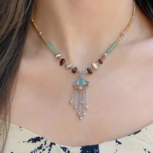 Tibetan crystal stone copper tassel necklace worn on model, showing authentic handmade beaded chain with jade accents and silver tassel pendant