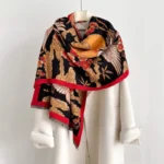 Black Tibetan crane plum blossom jacquard scarf worn on mannequin, showcasing auspicious cloud pattern with red trim