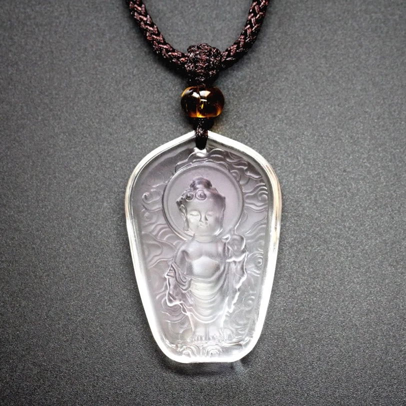Tibetan Buddha Liuli crystal pendant necklace with clear frosted transparent crystal, engraved Buddha figure with cloud patterns, spiritual jewelry on dark background