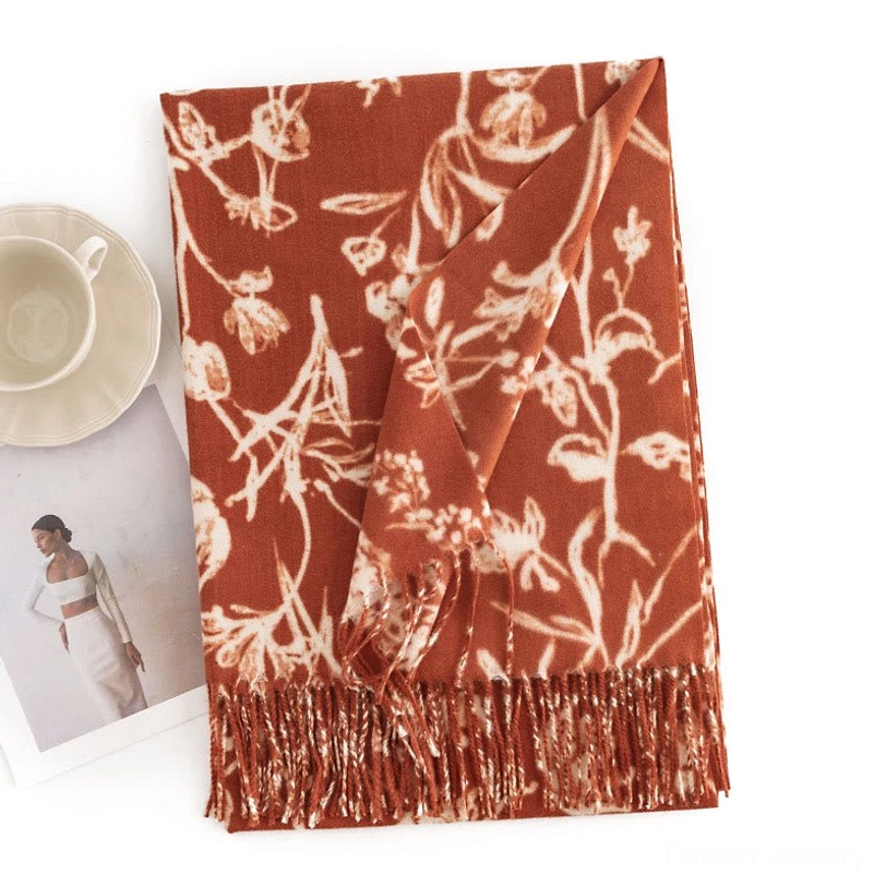 Dark orange Tibetan floral shawl wrap with warm tone, flat lay highlighting tassel trim and cozy aesthetic