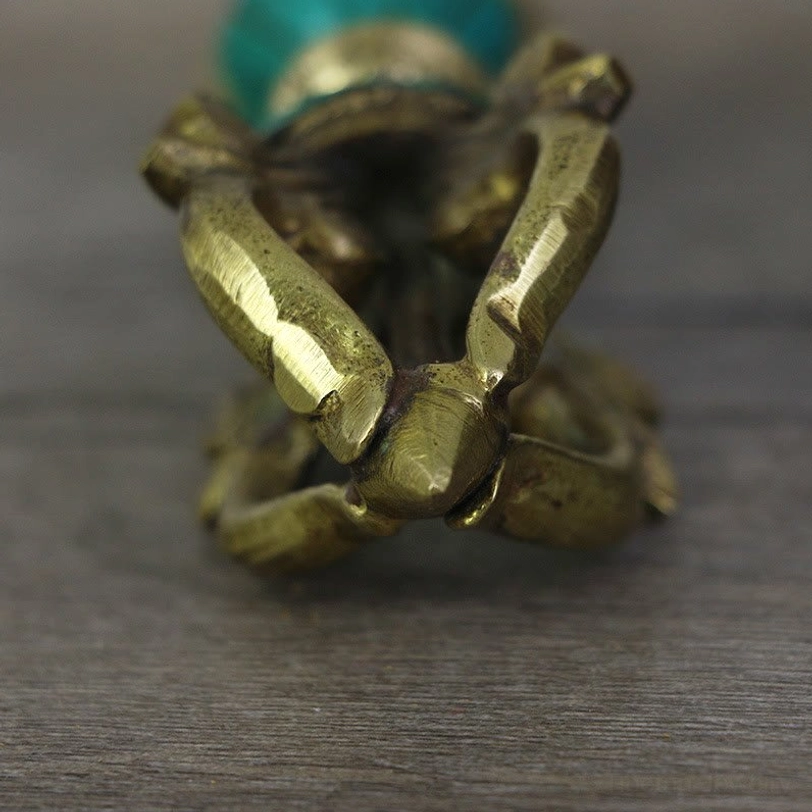 Close-up detail of five-prong vajra end showing interlocking metal prongs and textured copper finish