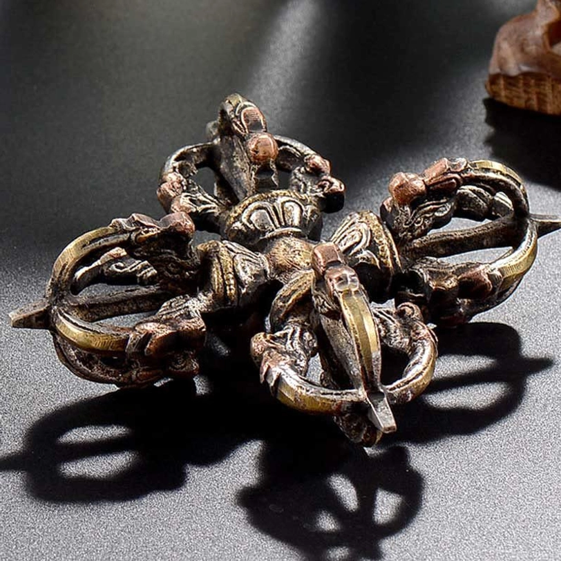 Tibetan double dorje vajra artifact showcasing authentic handmade copper and iron construction with spiritual Buddhist symbols