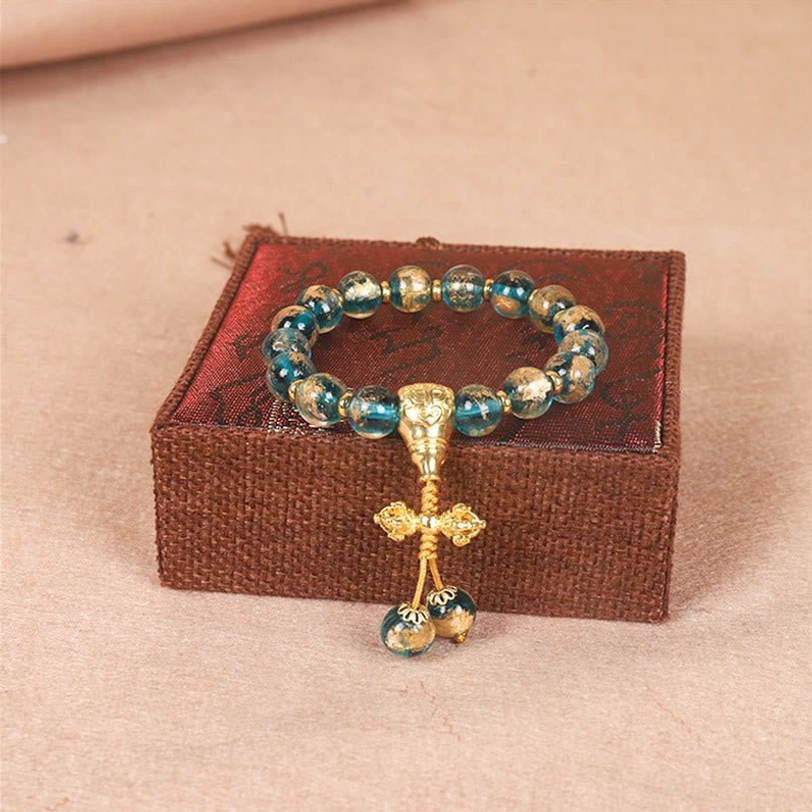 Tibetan Dorje vajra bracelet with blue glass beads and gold vajra pendant with bead dangles