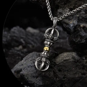 Dorje Vajra necklace overhead view featuring mythical creature ornamentations and dual-tone metal finish on dark rock background