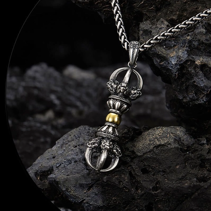 Dorje Vajra necklace overhead view featuring mythical creature ornamentations and dual-tone metal finish on dark rock background