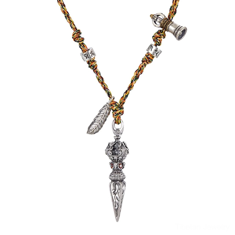 Front flat lay of intricate vintage-style Tibetan Dorje Vajra pendant necklace with silver bell charm and handwoven braided rope