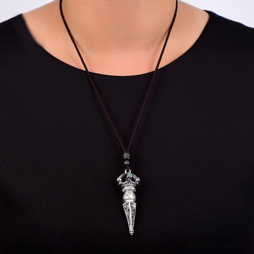 Wearable Tibetan Dorje Vajra pendant necklace worn on neck with brown wax cord, showing how the pendant sits close to the chest during wear