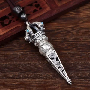 Top view of Tibetan Dorje Vajra pendant featuring black gem center, turquoise accents, and retro carved patterns on vintage wooden background