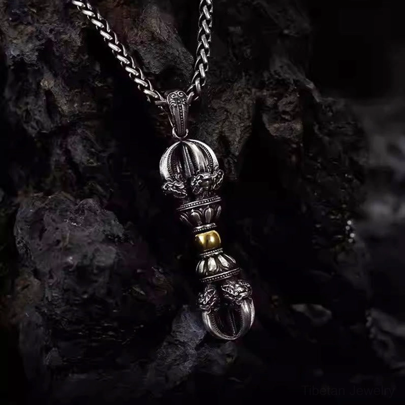 Vertical front view of Tibetan Dorje Vajra pendant on dark rock background with full structural visibility and gold center beads