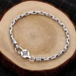 Tibetan double dorje om mani padme hum silver bracelet top view flat lay on wooden surface