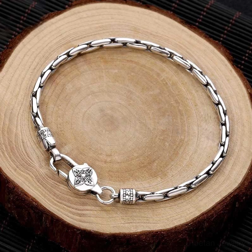 Tibetan double dorje om mani padme hum silver bracelet top view flat lay on wooden surface