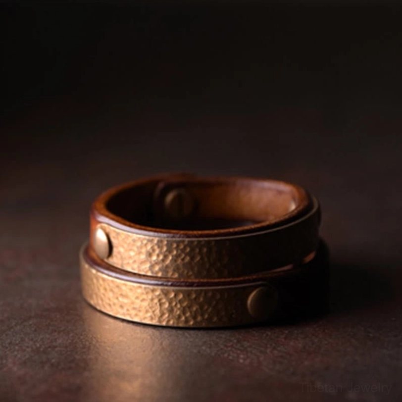 Double-layer stacked Tibetan wealth bracelet featuring brown leather with hammered brass panels and brass rivets, double cuff design