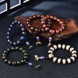 Multiple Dragon Vein Agate beaded bracelets displayed on wooden coaster showing color variety and craftsmanship