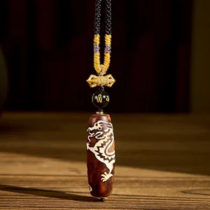 Tibetan dragon dzi necklace pendant featuring nine-eye agate bead with white dragon pattern and golden braided cord