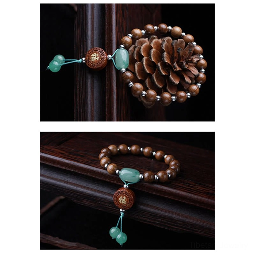 Sacred dragon wood abelia biflora bracelet with natural six-line beads, green jade accents, fu charm, and tassel beside pine cone