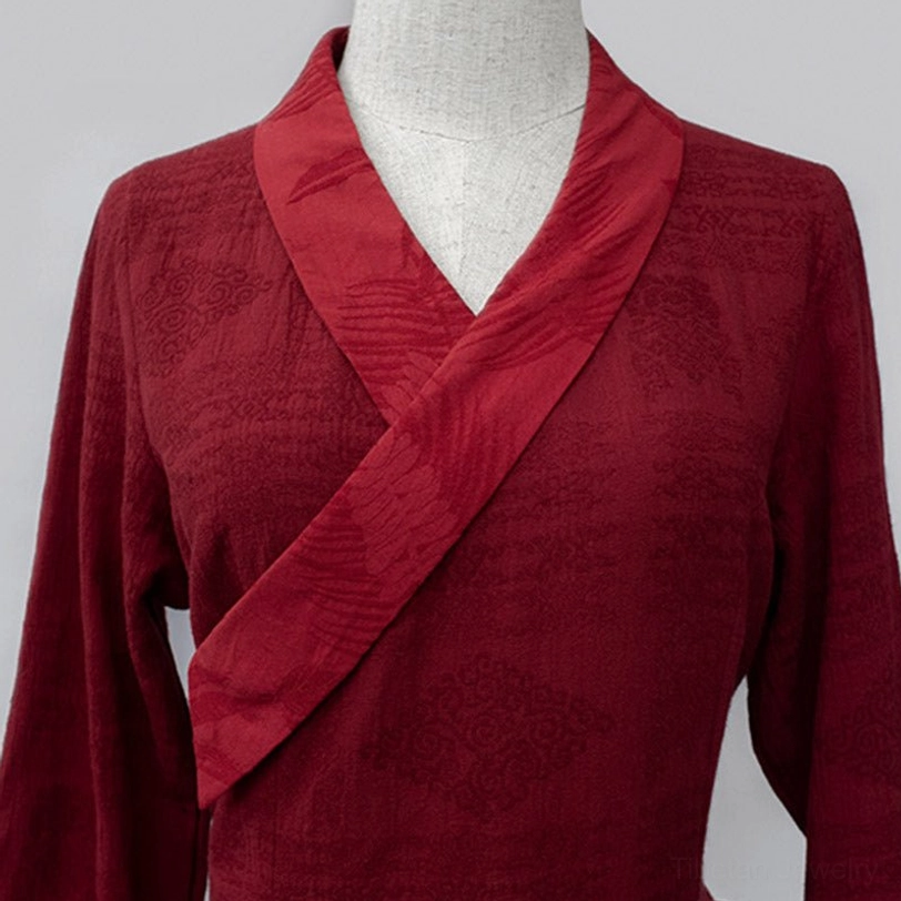 Close-up flat lay detail of Tibetan dress cross-wrap V-neck collar area showing burgundy handwoven fabric and cross-over neckline construction