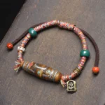 Handcrafted Tibetan nine-eye Dzi bead protection bracelet flat lay featuring colorful woven ropes and green spacer beads on wooden background