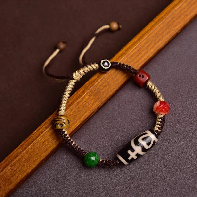 Handmade Tibetan nine-eye dzi bead bracelet with adjustable braided rope and multi-color accent beads, side view