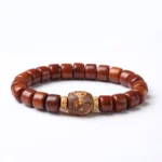 Tibetan three-eyed dzi bead bone bracelet with red agate and sheep horn top-down view