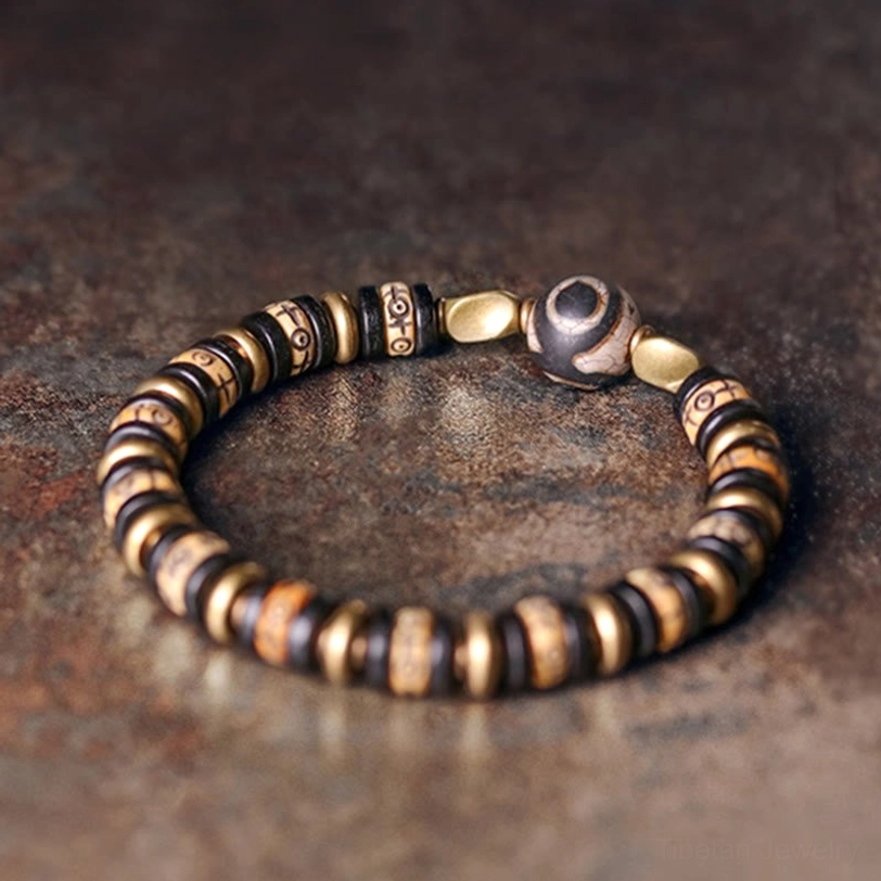 Sacred dzi bead tibetan bracelet with vintage metal accents close-up