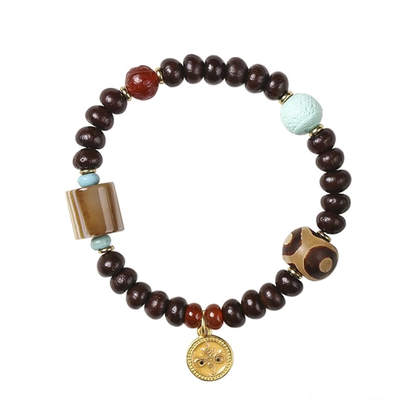 Handcrafted Tibetan Dzi bead bracelet featuring three-eye dzi amulet, purple bodhi beads, striped agate, red agate, turquoise, and gold accent