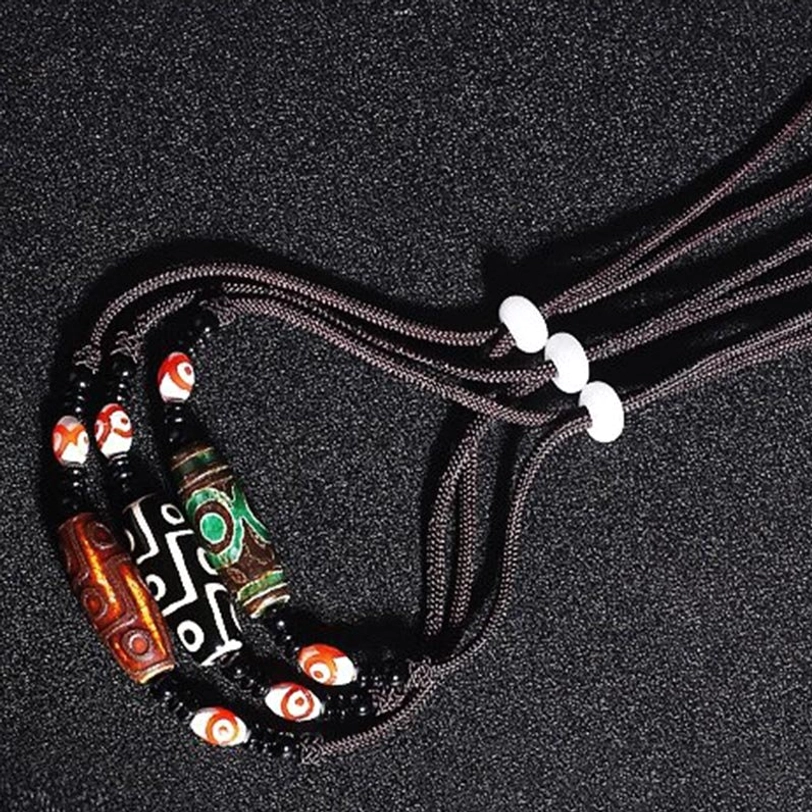Handmade Tibetan dzi bead necklace detail - natural stone pendant with protective eye patterns and spiritual significance