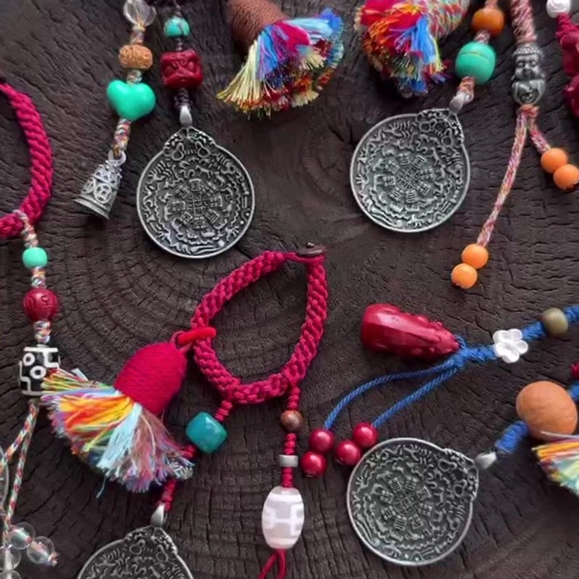 Collection of multiple Tibetan protective keychains displayed together showing various Dzi bead styles, braided ropes, and Bagua charms