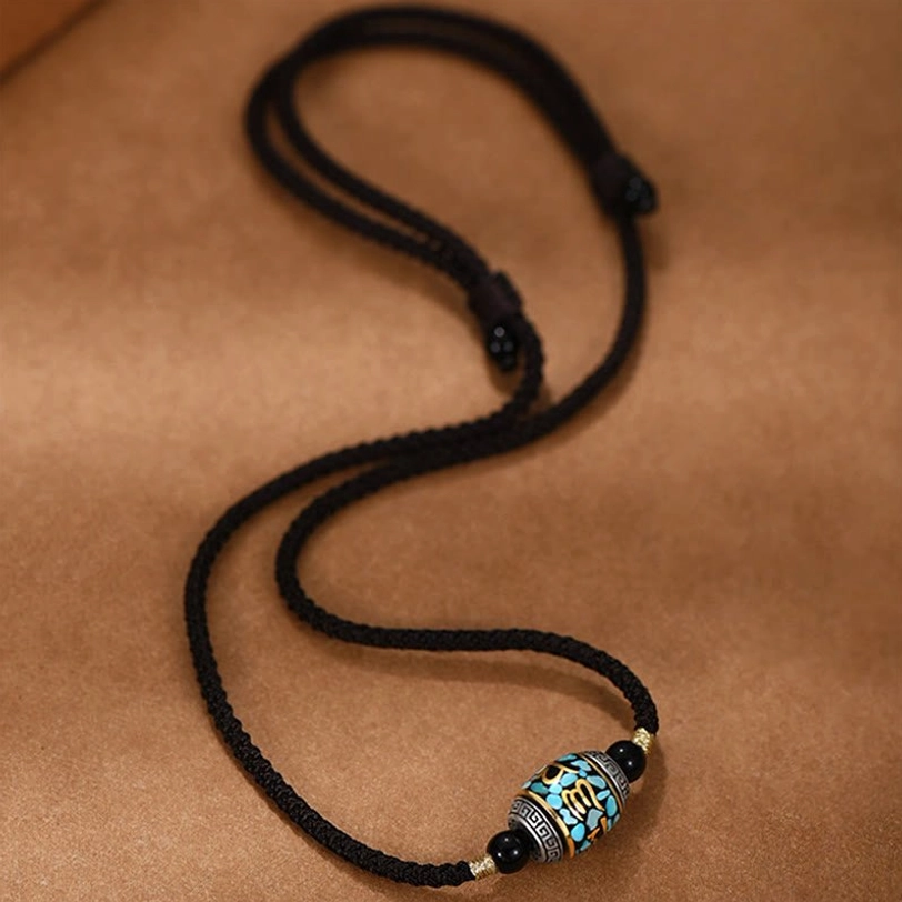 Extra-long Tibetan Om Mani Padme Hum necklace with barrel-shaped Dzi bead featuring turquoise and gold details on brown background