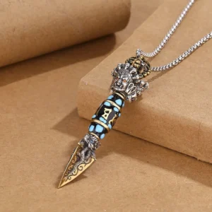 Tibetan Dzi Bead Rotatable Pendant Necklace with Om Mani Padme Hum and Dorje Vajra pattern, side overhead view showing hand-painted dragon carvings and turquoise inlays on kraft paper