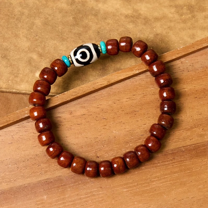 Tibetan three-eye Dzi bone bracelet with natural materials and spiritual significance