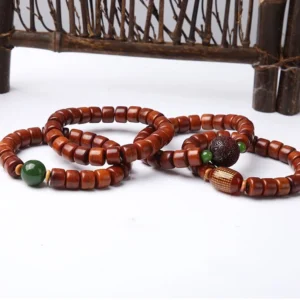 Collection of Tibetan bone bead bracelets with three-eyed dzi bead on vintage wooden display