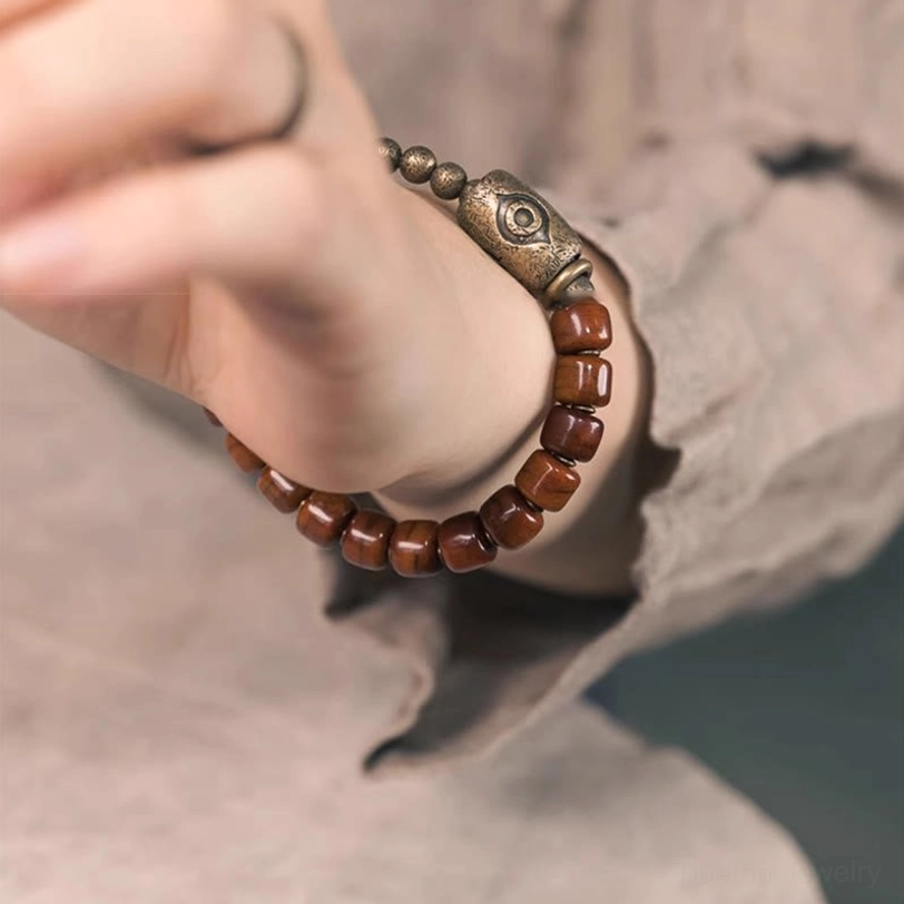 Handcrafted Tibetan Dzi bone bead bracelet with premium elastic string and protective copper accents, artisan jewelry detail