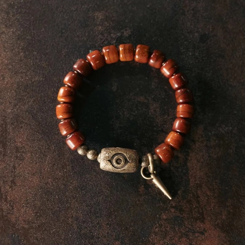 Complete circular view of handcrafted Tibetan bone bead bracelet with copper Dzi eye charm and protective accent beads