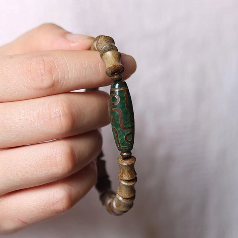 Nine-eye dzi green sandalwood spiritual protection bracelet detailed view showing bead quality and craftsmanship