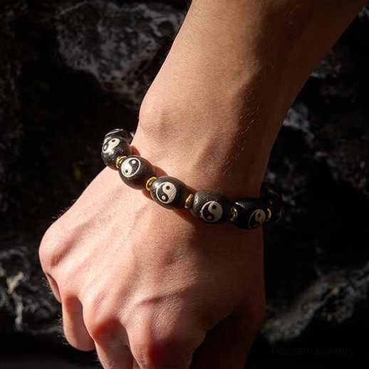 Close-up wrist wear view of Tibetan Dzi Bead Yin Yang bracelet on adult male wrist, demonstrating comfortable fit and natural appearance during daily wear