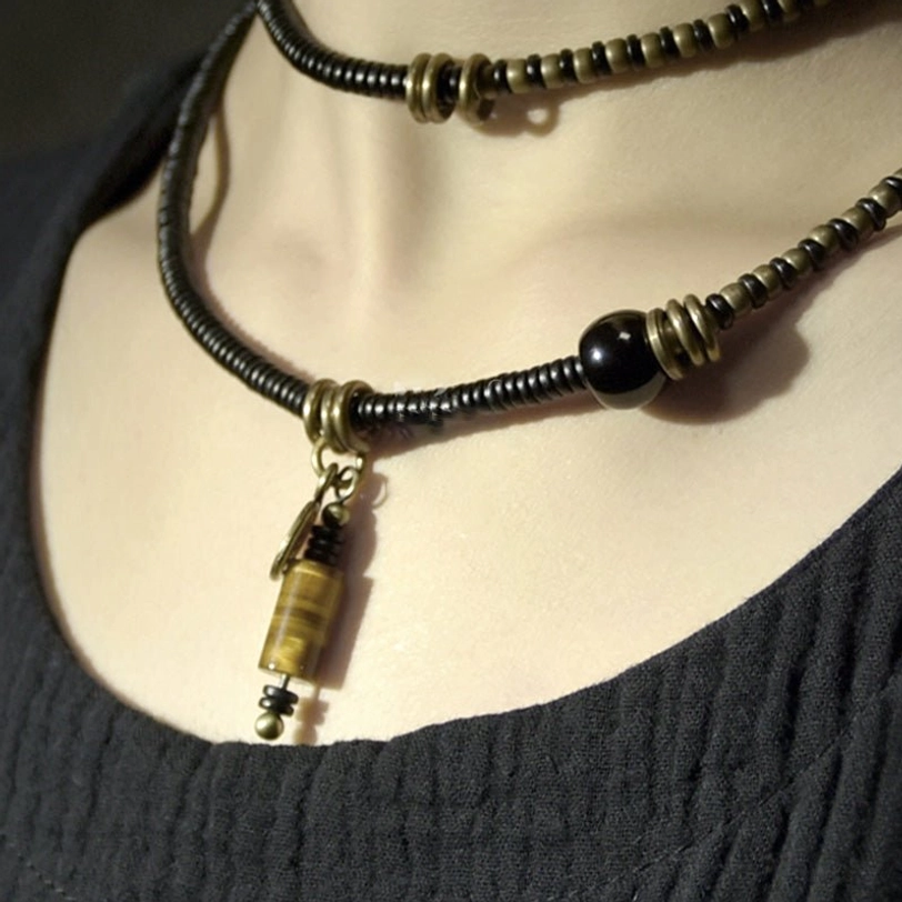 Dual-layer Tibetan Dzi choker necklaces with black beads and coordinated copper metal stone pendant, close-up on mannequin neck